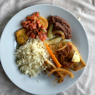 Pescado, arroz, frijoles, tostones con ensalada criolla